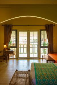 a bedroom with a bed and a room with windows at Hotel Deli River and Restaurant Omlandia in Medan +143 photos