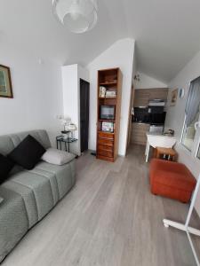 a living room with a couch and a table at Jardin Fleuri - Proche Foix in Saint-Paul-de-Jarrat