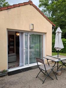 a chair and an umbrella in front of a house at Jardin Fleuri - Proche Foix in Saint-Paul-de-Jarrat