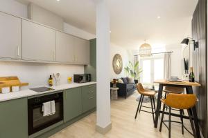 a kitchen with green cabinets and a living room at Relaxed, Spacious & Ideal for Small Families in Bournemouth