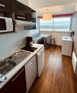 a kitchen with a sink and a counter top at Appartement duplex vue mer in Audierne
