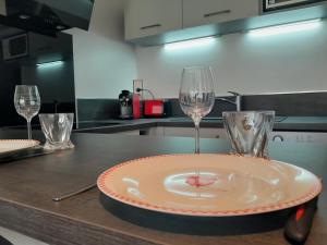 a plate and two wine glasses on a kitchen counter at Appartement à 100m de la plage in Mandelieu-la-Napoule +3 photos