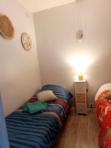 a small bedroom with a bed and a lamp at Appartement à 100m de la plage in Mandelieu-la-Napoule