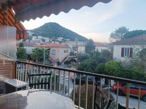 a balcony with a view of a city and a mountain at Appartement à 100m de la plage in Mandelieu-la-Napoule
