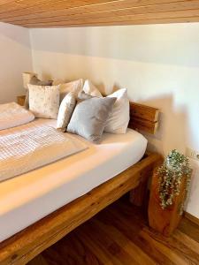 ein Bett mit Kissen darauf in einem Zimmer in der Unterkunft Castle and Alps Appartement in Halblech