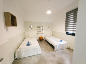 ein Zimmer mit zwei Betten und einem Fernseher in der Unterkunft Caesar Resort 2 Bedroom Deluxe Home in Iskele