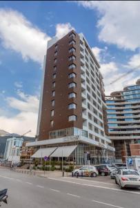 a tall building with cars parked in a parking lot at Budva Wow 503 in Budva