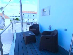 ein Zimmer mit zwei Stühlen und einem Couchtisch auf einem Balkon in der Unterkunft Pinhal Litoral in Marinha Grande + 32 Fotos