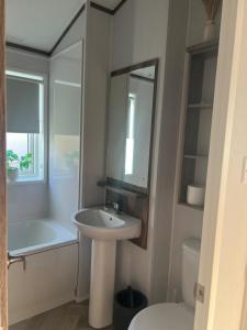 ein Badezimmer mit Waschbecken, Badewanne und Toilette in der Unterkunft NEW 2025 Modern 3Bedrooms Lodge Walk to Beach in Morecambe + 34 Fotos