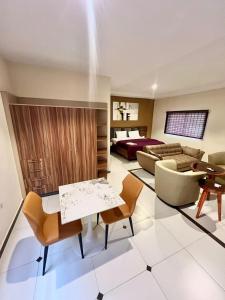 ein Wohnzimmer mit Sofa, Tisch und Stühlen in der Unterkunft Elegant Studio Haven Offering Peace, Comfort & Style in Mama