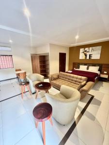 ein großes Wohnzimmer mit einem Sofa und einem Bett in der Unterkunft Elegant Studio Haven Offering Peace, Comfort & Style in Mama + 2 Fotos