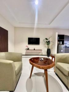 ein Wohnzimmer mit einem Couchtisch und einem TV in der Unterkunft Elegant Studio Haven Offering Peace, Comfort & Style in Mama