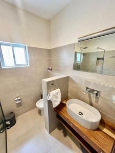 ein Badezimmer mit Waschbecken und Toilette in der Unterkunft Elegant Studio Haven Offering Peace, Comfort & Style in Mama