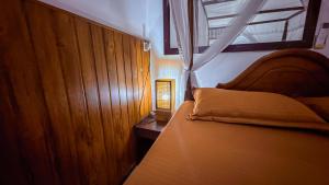 ein Schlafzimmer mit einem Bett und einer Lampe auf einem Tisch in der Unterkunft Samudura Beach House, Owakanda in Ratgama Hegoda