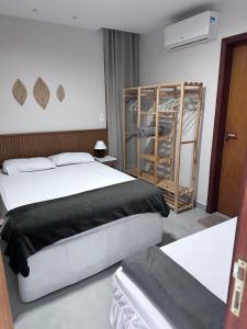 a bedroom with a bed and a book shelf at Praia do Forte - Mansão Sunset in Mata de Sao Joao