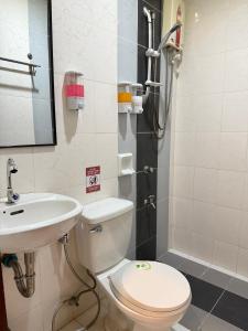 ein Badezimmer mit Toilette und Waschbecken in der Unterkunft Cozy Stop Inn - Puerto Princesa in Puerto Princesa + 10 Fotos