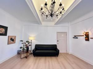 a living room with a black couch and a chandelier at Shanghai Zighouse--The Bund Premium Apartment Suites in Shanghai