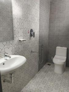 ein Badezimmer mit Waschbecken und Toilette in der Unterkunft Hotel Lynx in Kumbakonam