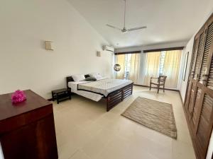 a bedroom with a bed and a couch in a room at Sandbox in Kilifi