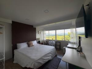 a bedroom with a bed and a large window at BaanPhutawanLanta in Ban Mo Nae