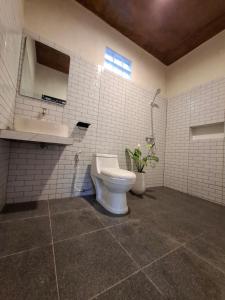 a white bathroom with a toilet and a sink at Mini Village in Batukaras +35 photos