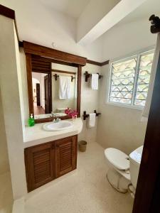 a bathroom with a toilet and a sink and a mirror at Sandbox in Kilifi +25 photos