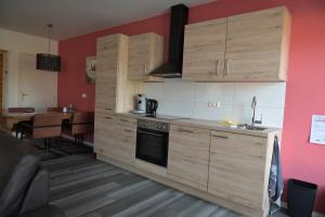 a kitchen with wooden cabinets and a dining room at B&B gewoon Prins in Wichmond