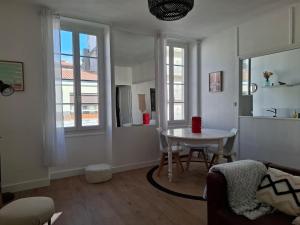 a living room with a table and a kitchen at Cozy Go in Rochefort