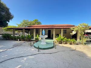 a statue in front of a house with a building at Sitio Família Freitas in Pindoretama