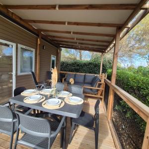un patio con tavolo e sedie su un ponte di Le Havre de Paix Mobil home a 200m de la Plage Parc Aquatique Camping 5 Etoiles a Torreilles Altre 23 foto