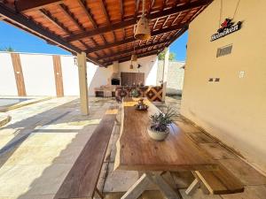 a patio with a wooden table and a fireplace at Sitio Família Freitas in Pindoretama
