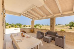 a patio with a table and chairs and a view at Villa Serenella in Carovigno