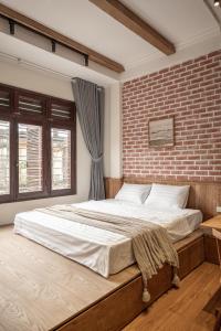 a bedroom with a large bed with a brick wall at Brown Villa with Rooftop Pool - Free Laundry - Near Old Quarter in Hanoi