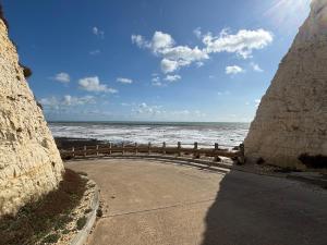 a road next to the ocean on a sunny day at Cairo House in Peacehaven