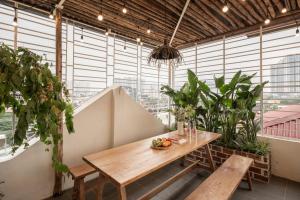 a table and benches in a room with plants at Brown Villa with Rooftop Pool - Free Laundry - Near Old Quarter in Hanoi