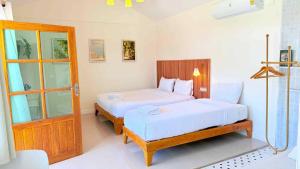 a bedroom with two beds and a door at sleep private khaoya unit03 in Mu Si
