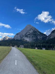 a road leading into a field with mountains in the background at Casa Auroranna in Sappada