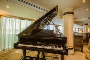 a piano in a room with a column at Sonesta St George Nile Cruise - Luxor to Aswan 4 Nights from Monday to Friday in Luxor