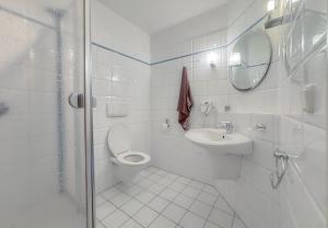 a white bathroom with a toilet and a sink at Hotelkamer voor twee personen in Bunkenburg
