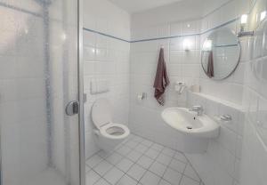 a white bathroom with a toilet and a sink at Hotelkamer voor twee personen in Bunkenburg +10 photos