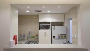 eine Küche mit weißen Schränken und einem weißen Kühlschrank in der Unterkunft MK luxury apartments in Riad