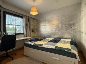 a bedroom with a bed and a desk and a chair at Nordic Nest in Vantaa