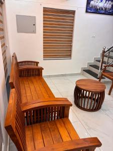 a wooden bench and a table in a room at Prasadam Inn Varkala in Varkala