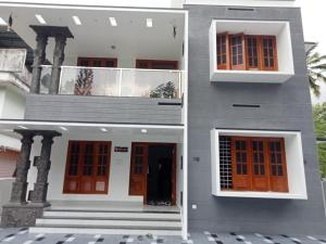 a building with orange and white doors and stairs at Prasadam Inn Varkala in Varkala