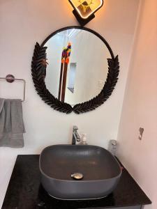 a bathroom with a black sink and a mirror at Prasadam Inn Varkala in Varkala +26 photos