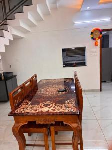 a wooden table with two chairs and a table with at Prasadam Inn Varkala in Varkala