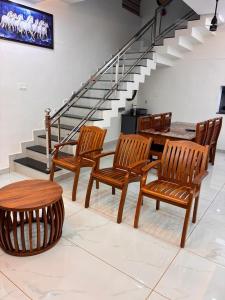 a group of wooden chairs and a table and stairs at Prasadam Inn Varkala in Varkala