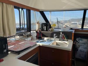 une cuisine avec un évier et une vue sur un bateau dans l'établissement luxueux bateau à quai, à Sari-Solenzara