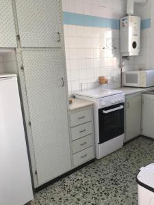 a small kitchen with a stove and a refrigerator at La Musclera L5, apartament aprop de la platja del Pas in Port de la Selva