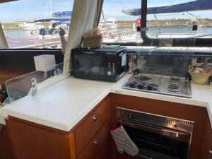 une cuisine équipée d'un micro-ondes et d'une plaque de cuisson sur un bateau dans l'établissement luxueux bateau à quai, à Sari-Solenzara 5 autres photos